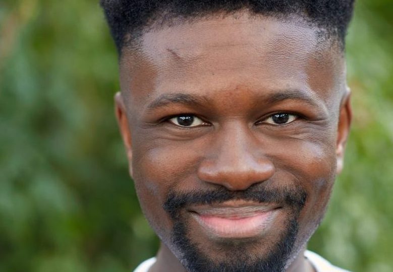 a picture of a black man with a goatee beard smiling at the camera.