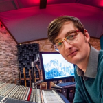 a man sits at a mixing desk