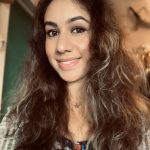 a woman with long curly hair smiling at the camera