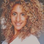 a woman smiling with blonde curly hair 